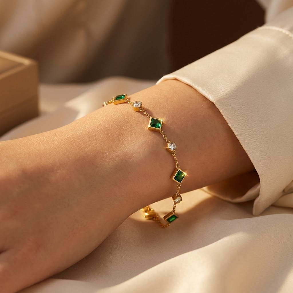 Pulseira de ouro com esmeraldas, estilo estação, da marca Rose & Oliver, exibindo joias delicadas e elegantes com detalhes verdes.