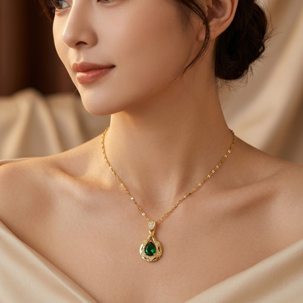 Colar de ouro com pingente de gota de esmeralda, estilo elegante, da marca Rose & Oliver, pendurado em uma corrente delicada.