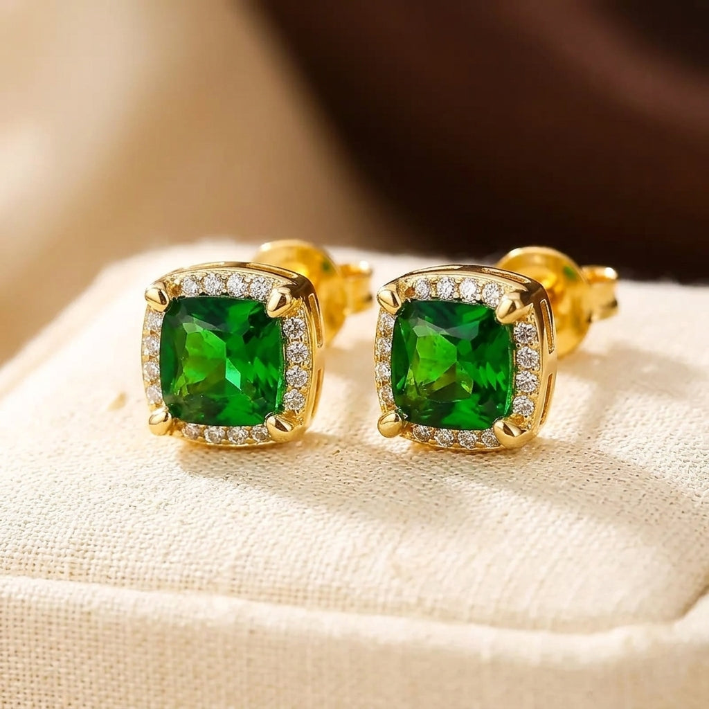 Brincos de ouro com esmeraldas em halo, estilo joias da Rose & Oliver, com pedras verdes e acabamento elegante.