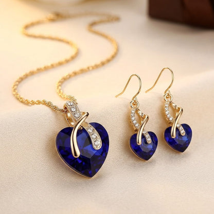 Conjunto de brincos de ouro com safira em formato de coração, da marca Rose & Oliver, exibindo detalhes delicados e elegantes.