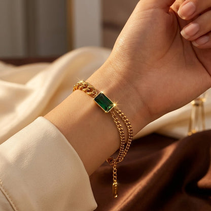 Pulseira de corrente com barra de ouro e esmeraldas da Rose & Oliver, detalhes delicados e acabamento elegante.