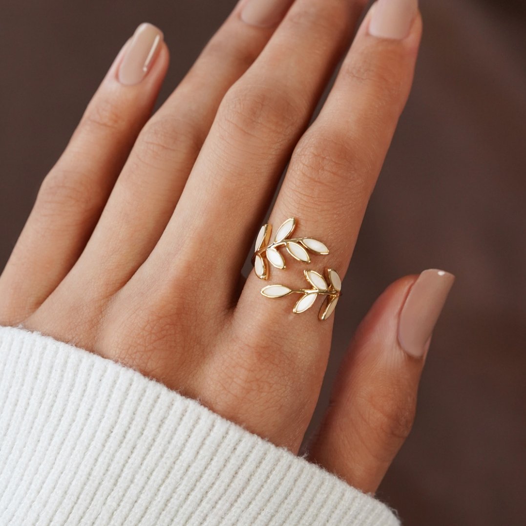 Anel de ouro com padrão de folhas douradas, design elegante da marca Rose & Oliver, visível detalhes de acabamento.